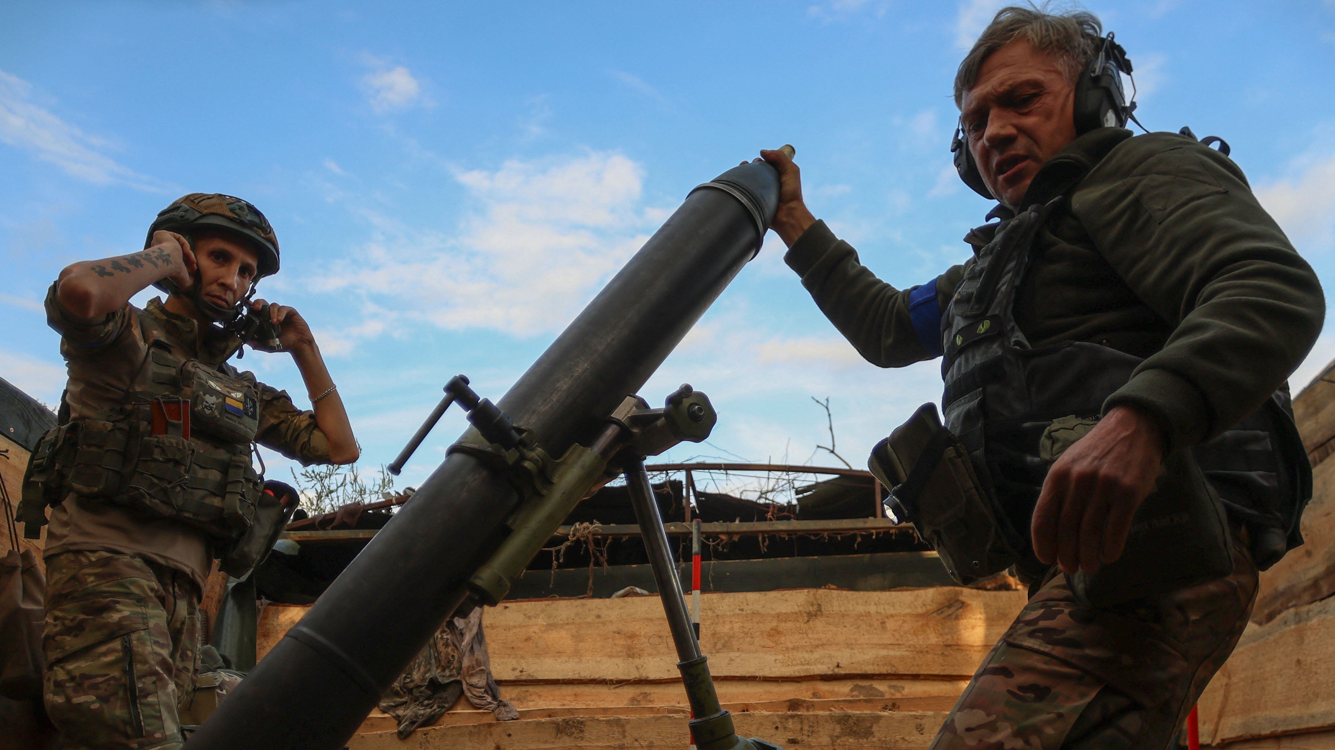 Ukrainian service members fire a mortar toward Russian troops at their position near a frontline in Zaporizhzhia region