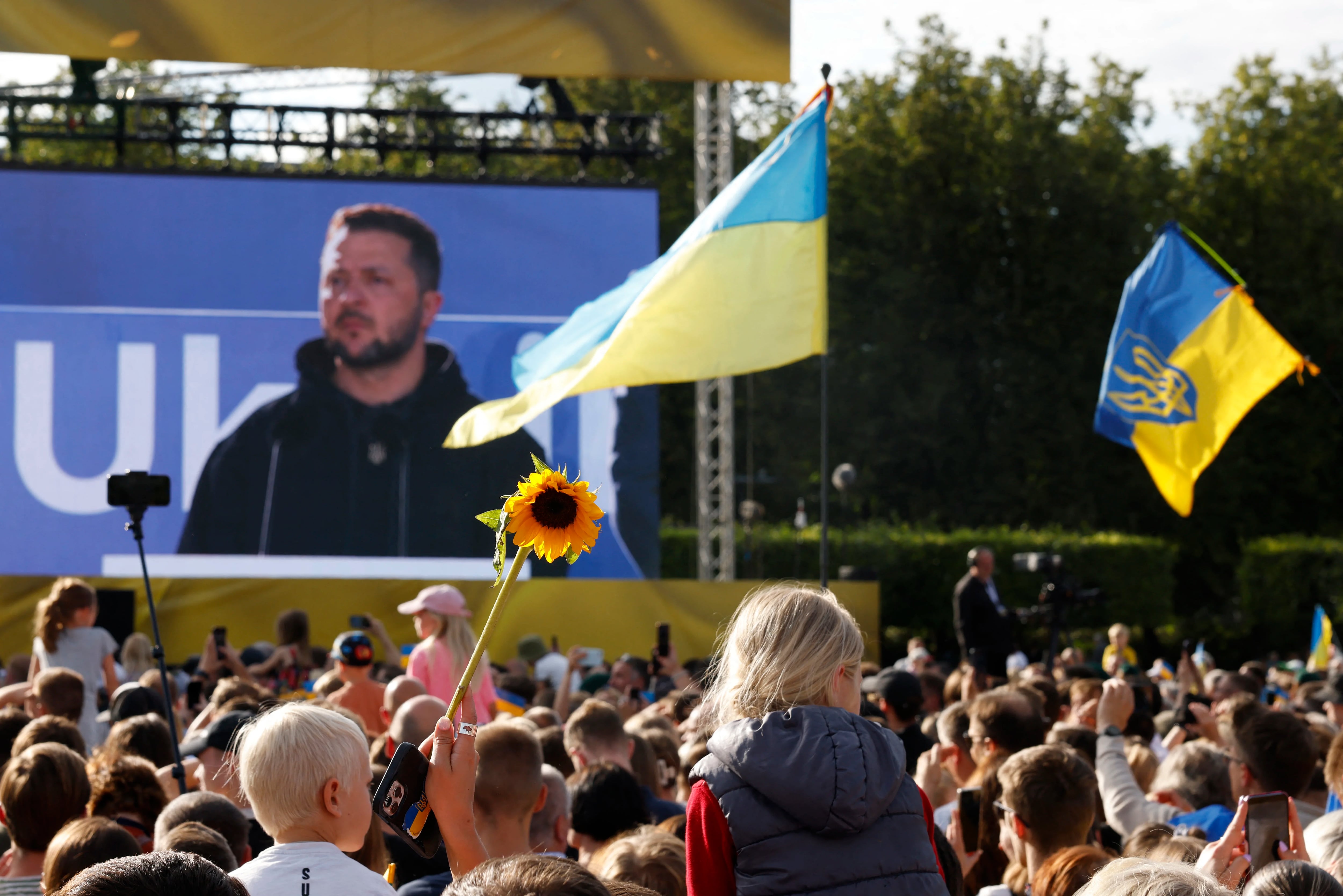 Zelensky aparece en una pantalla gigante mientras habla en Lituana Photo by Odd ANDERSEN / AFP)