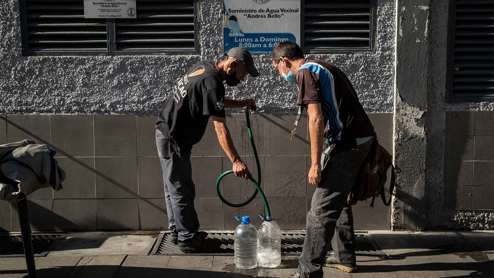 Ante la vuelta del agua, decenas de vecinos llenan sus bidones y baldes para tener de reserva (EFE)