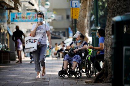 People wear protective face masks at a main street as Israel began easing a second nationwide coronavirus disease (COVID-19) lockdown, in Ramat Gan, Israel October 18, 2020. REUTERS/Amir Cohen