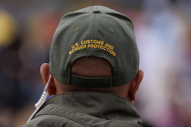 Un agente de la patrulla fronteriza estadounidense vigila a los migrantes reunidos entre las vallas fronterizas cerca de San Diego, California, Estados Unidos (REUTERS/Mike Blake/Archivo)