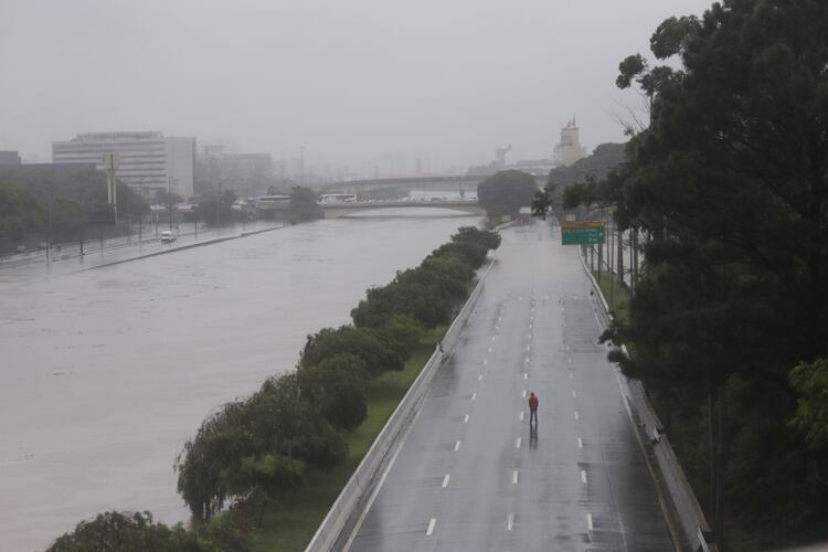 Un hombre camina sobre una autopista Marginal Tiete parcialmente inundada después de fuertes lluvias en Sao Paulo, Brasil, 10 de febrero de 2020. (REUTERS / Rahel Patrasso)