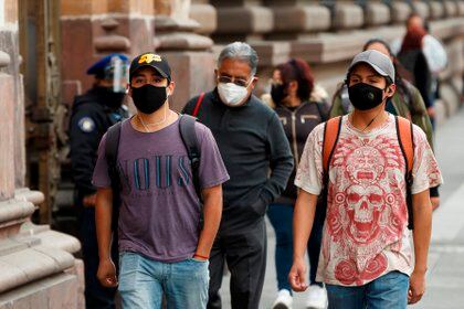 MEX3052. CIUDAD DE MÉXICO (MÉXICO), 07/01/2021.- Varias personas caminan en la calle hoy, en Ciudad de México (México). Las primeras inyecciones contra la covid-19 llegaron a territorio mexicano el día de Nochebuena y permitieron cerrar el año con un mensaje optimista, pero dos semanas después, con los Reyes Magos ya de regreso a Oriente, la sombra del desorden, la lentitud y del tráfico de influencias para vacunarse opacan el plan de inmunización. EFE/ José Mendez
