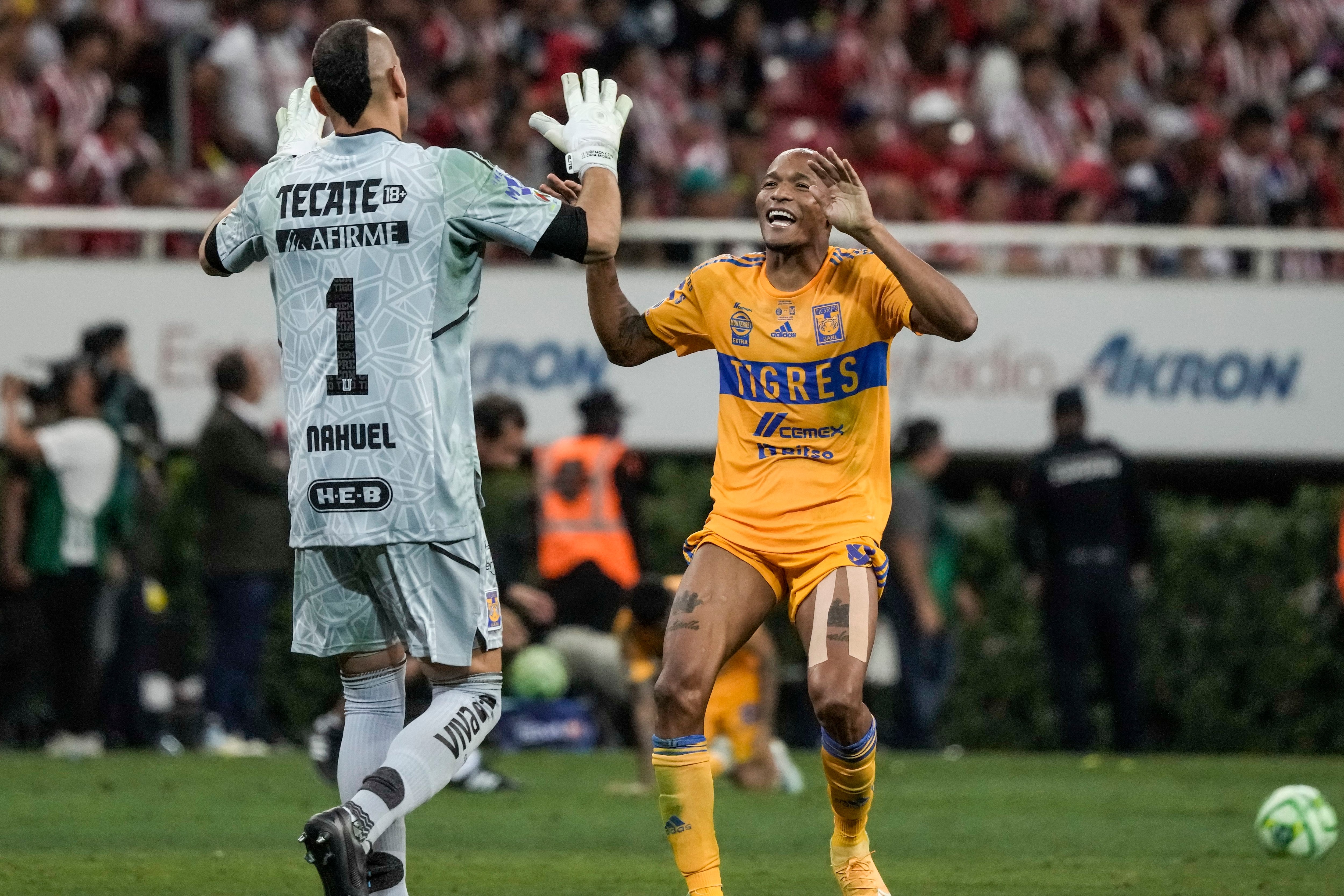 El arquero Nahuel Guzmán (izquierda) y Luis Quiñones celebran el tercer gol de Tigres en la victoria 3-2 ante Guadalajara en la final de la Liga MX, el domingo 28 de mayo de 2023, en Guadalajara. (AP Foto/Eduardo Verdugo)