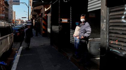 Personas con tapabocas caminan frente a tiendas cerradas por la situaci&#243;n del coronavirus, en la ciudad de Sao Paulo (Brasil). EFE/Sebasti&#227;o Moreira
