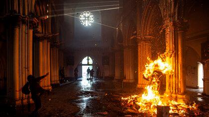 Vista de un incendio provocado por manifestantes dentro de la iglesia San Francisco de Borja durante enfrentamientos con la policía antidisturbios en la conmemoración del primer aniversario del levantamiento social en Chile. (Photo by MARTIN BERNETTI / AFP)