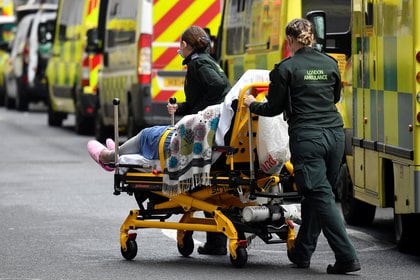 Trabajadores médicos sacan a un paciente de una ambulancia, en medio de la pandemia del COVID-19, frente al Hospital Real de Londres el 15 de enero de 2021 (REUTERS/Toby Melville)