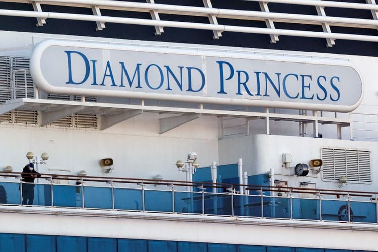 FOTO DE ARCHIVO: Un pasajero con una mascarilla se encuentra en la cubierta del crucero Diamond Princess, mientras los pasajeros del buque siguen siendo examinados para detectar el coronavirus, en la Terminal de Cruceros del Muelle Daikoku en Yokohama, al sur de Tokio, Japón 13 de febrero de 2020. REUTERS/Kim Kyung-Hoon/File Photo