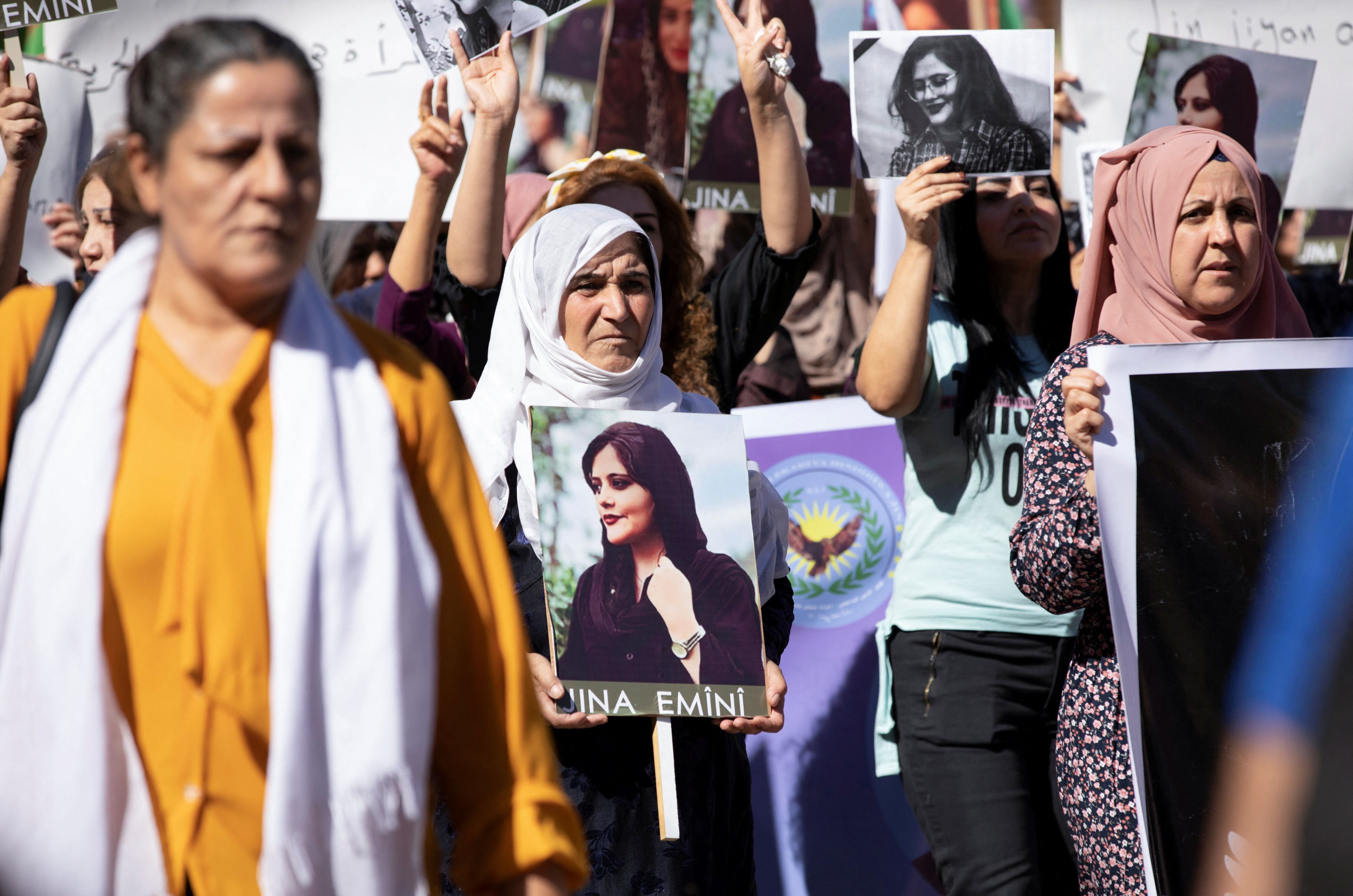 Mujeres portan fotos durante una protesta por la muerte de la mujer kurda de 22 años Mahsa Amini en Irán, en la ciudad de Qamishli, controlada por los kurdos, en el noreste de Siria el 26 de septiembre de 2022.  REUTERS