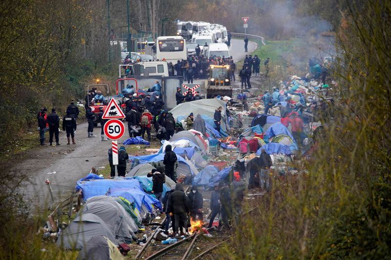 Los inmigrantes se reúnen mientras los policías franceses desmantelan su campamento improvisado en la playa de Loon, cerca de Dunkerque, Francia, 30 de noviembre de 2021. REUTERS/Juan Medina
