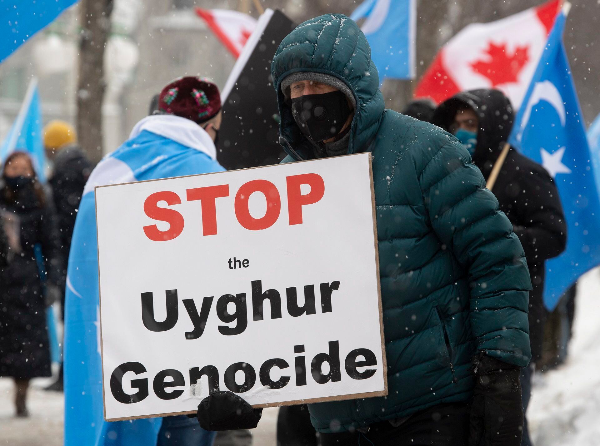 Protesters gather outside the Parliament buildings in Ottawa, Ontario Monday, Feb. 22, 2021. Parliament is expected to vote on an opposition motion calling on Canada to recognize China's actions against ethnic Muslim Uighurs as genocide.  (Adrian Wyld / The Canadian Press via AP)
