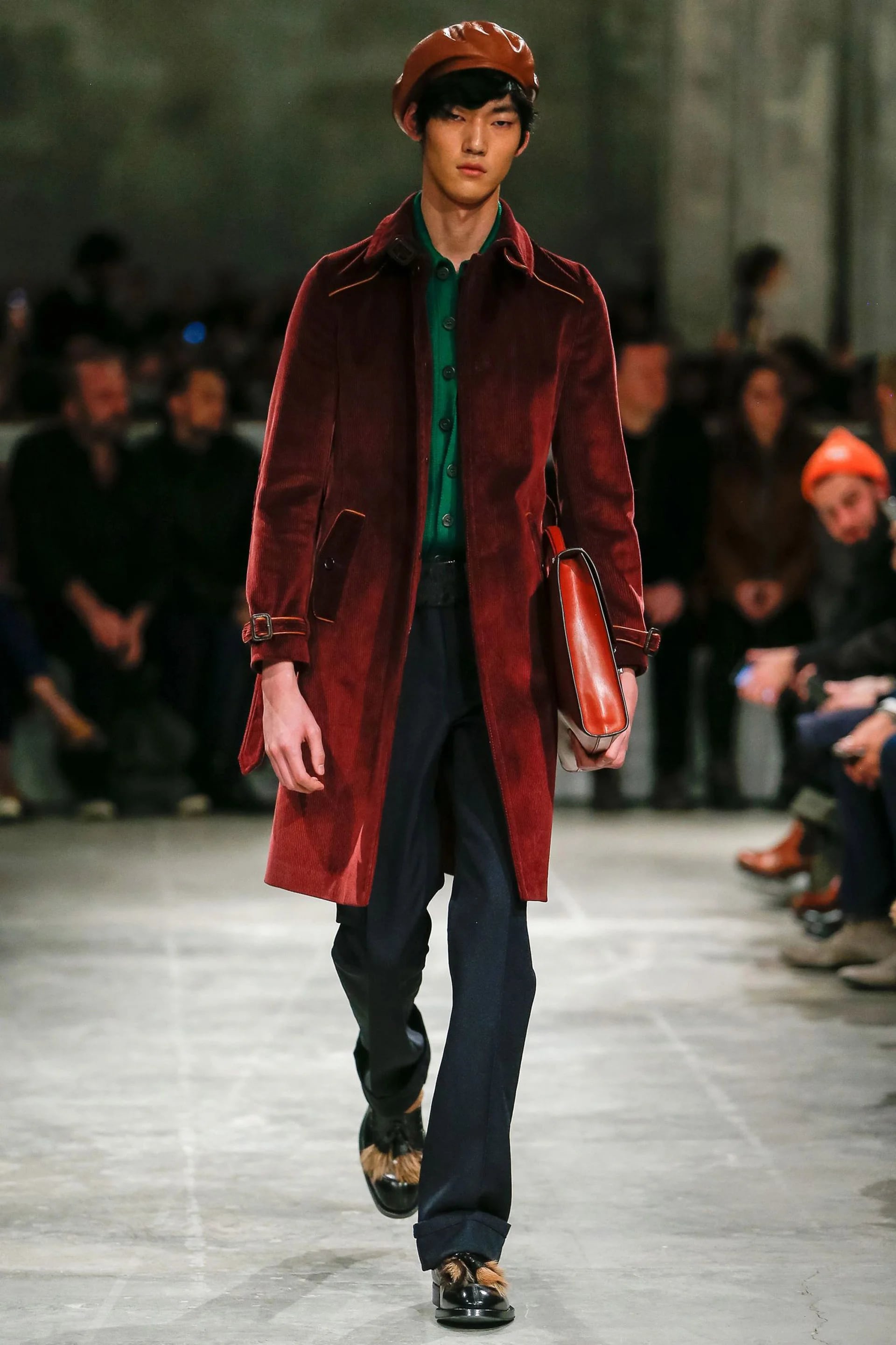 Prada no se quedó atrás con la tendencia de los trench-tapados de corderoy, lució en pasarela en color borravino en combinación con pantalones azules y verde esmeralda en la camisa.