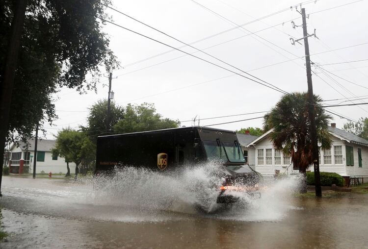 A United Postal Service truck creates a wake on 39th Street as Tropical Storm Imelda rains down on Galveston, Texas on Wednesday, Sept. 18, 2019. The storm has not caused damage in businesses or houses as of Wednesday afternoon. ( Kelsey Walling/The Galveston County Daily News via AP)