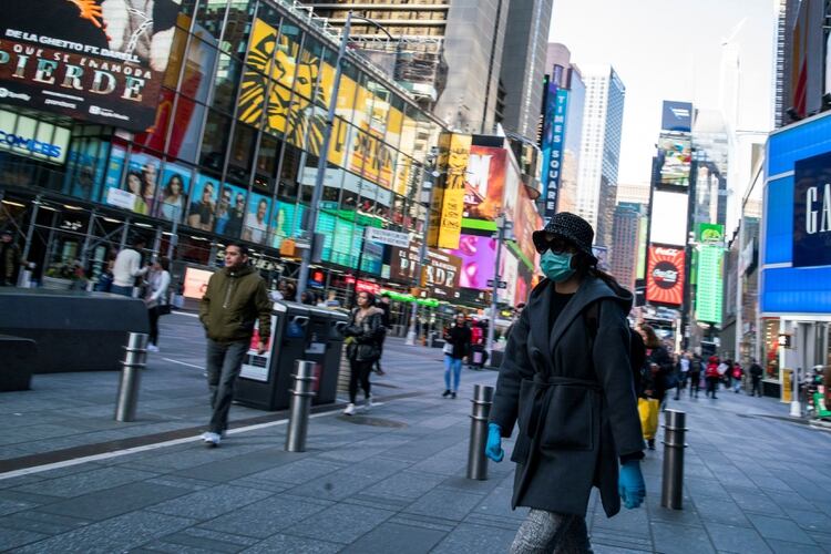 Una mujer pasea con guantes y mascarilla por Times Square. REUTERS/Eduardo Munoz