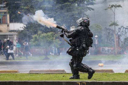 Un policía dispara gases lacrimógenos a manifestantes en Bogotá, Colombia, el jueves 21 de noviembre de 2019. (AP Foto / Ivan Valencia)