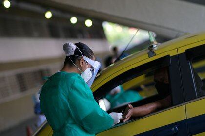 Un trabajador de salud realiza pruebas de coronavirus a los taxistas en el Sambódromo de Río de Janeiro, Brasil, 26 de junio de 2020.REUTERS/Ricardo Moraes