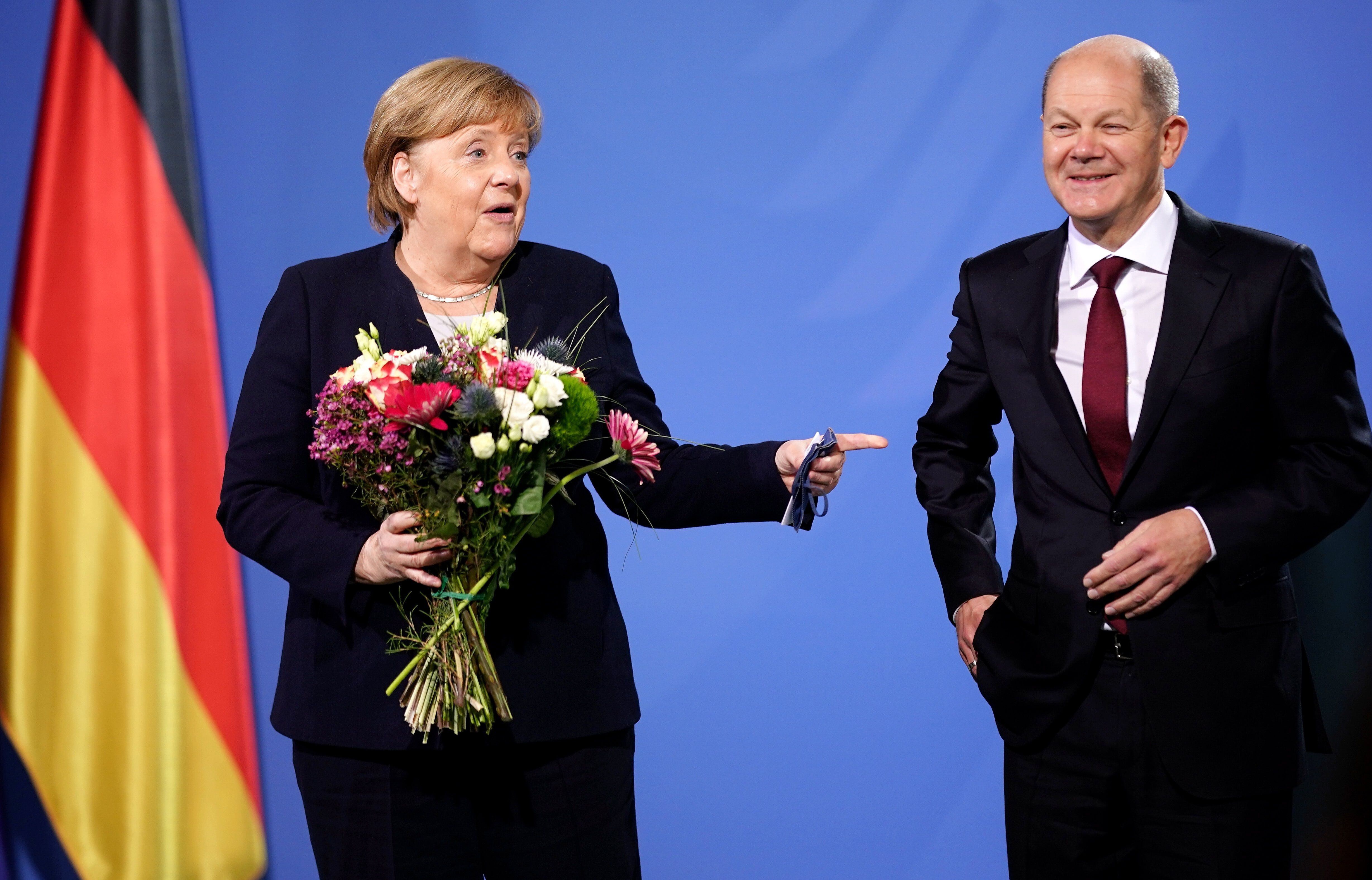 El canciller alemán, Olaf Scholz, junto a su antecesora en el cargo, Angela Merkel, durante su ceremonia de investidura en el cargo, este miércoles en Berlín. EFE/CLEMENS BILAN