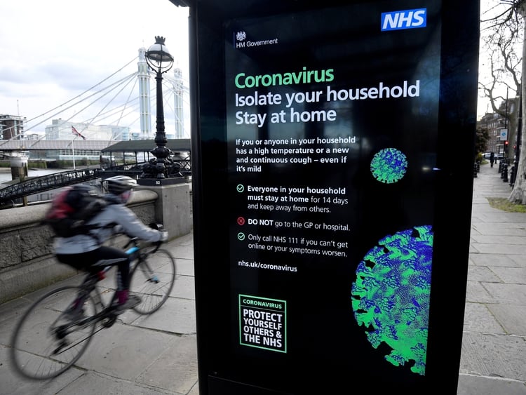 FILE PHOTO: A cyclist rides past a UK government public health campaign poster as the spread of the coronavirus disease (COVID-19) continues, in London, Britain, March 20, 2020. REUTERS/Toby Melville/File Photo