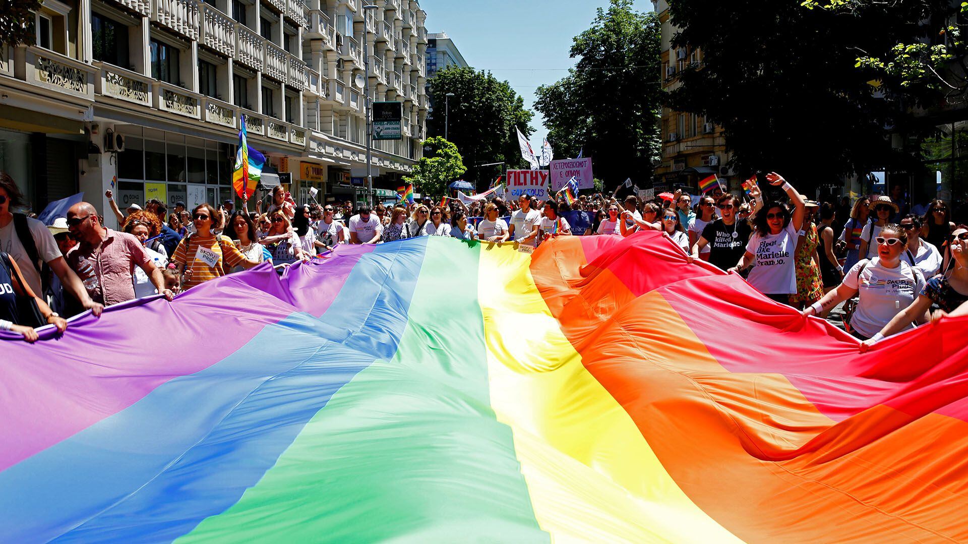 Miles de personas sostienen la bandera con los colores que reivindican la lucha de la comunidad LGBTI+  (REUTERS/Ognen Teofilovski)