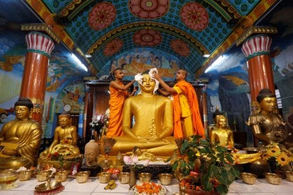 Monjes budistas limpian la estatua del Buda dentro de un templo en preparación para el Día de Vesak en Kolkata, India el 9 de mayo de 2017. (Reuters)
