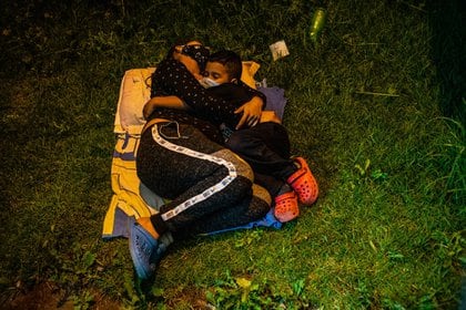 Sebastián y su madre, Jessika Loaiza, duermen cerca de una parada de camiones en una de sus primeras noches del trayecto