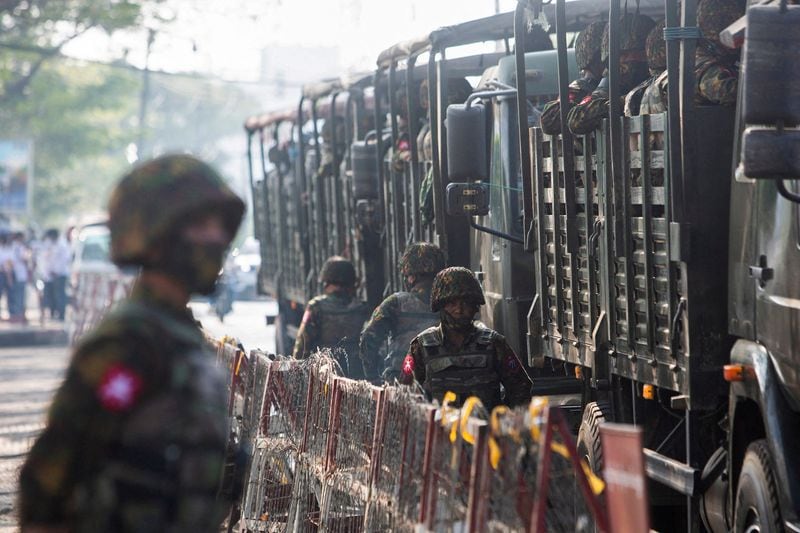 FOTO DE ARCHIVO: Soldados junto a vehículos militares mientras la gente se reúne para protestar contra el golpe militar, en Yangon, Myanmar, 15 de febrero de 2021. REUTERS/Stringer/File Photo