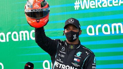 Formula One F1 - Eifel Grand Prix - Nurburgring, Nurburg, Germany - October 11, 2020 Mercedes' Lewis Hamilton poses with a red helmet from Mick Schumacher after winning the race   FIA/Handout via REUTERS??ATTENTION EDITORS - THIS IMAGE HAS BEEN SUPPLIED BY A THIRD PARTY. NO RESALES. NO ARCHIVES