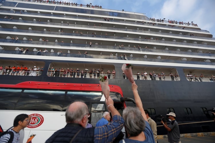 Los pasajeros agitan las manos después de salir del MS Westerdam (REUTERS/Stringer)
