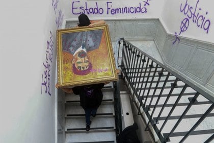 Colectivas de feministas cargaron uno de los cuadros intervenidos durante el tercer día de la toma de las instalaciones