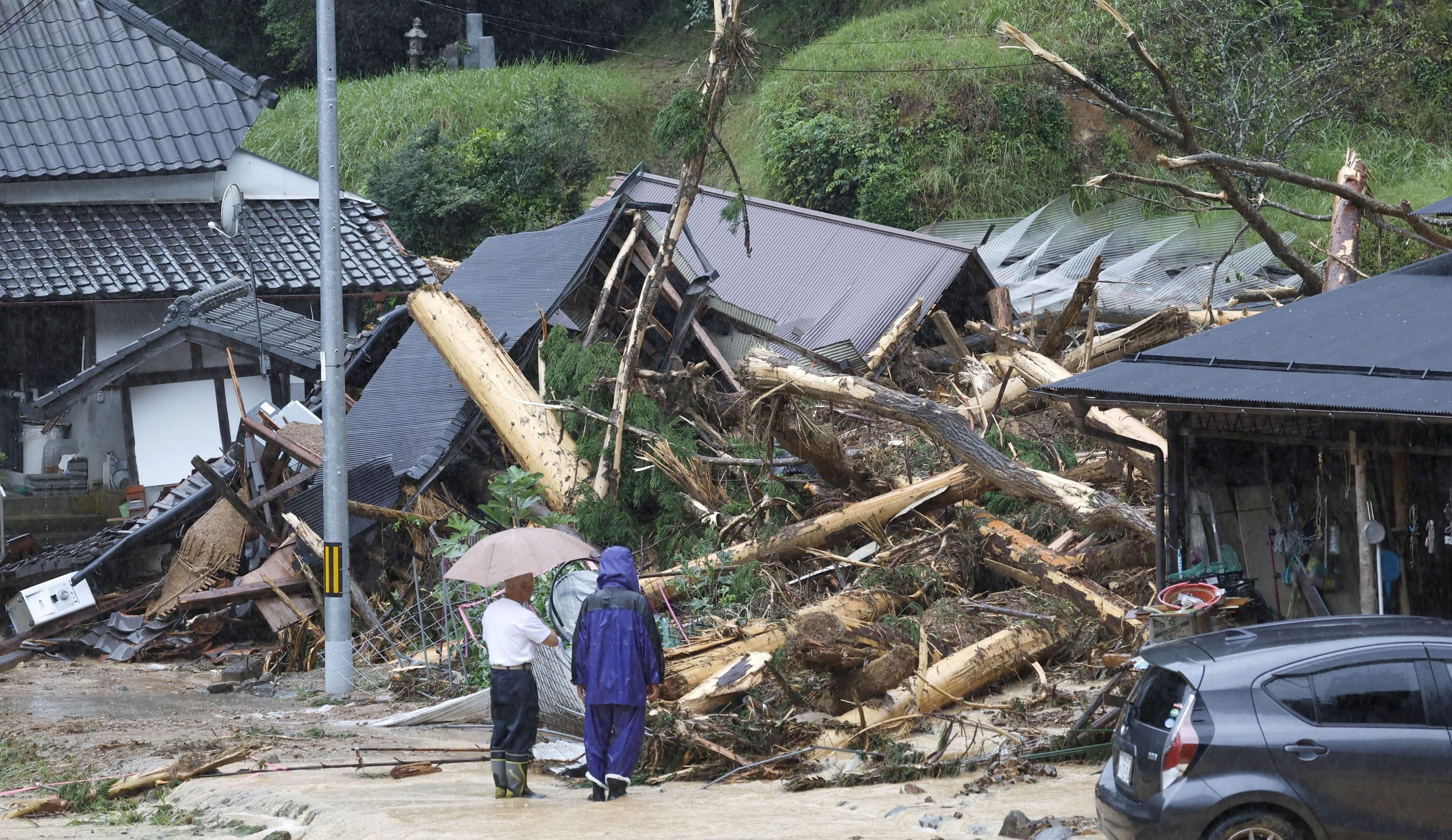 Los residentes locales miran un sitio de deslizamiento de tierra causado por el tifón Lan en Ayabe, prefectura de Kioto, Japón occidental 15 de agosto 2023, en esta foto tomada por Kyodo.  Crédito obligatorio Kyodo via REUTERS 