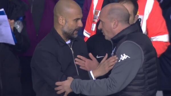 Pep Guardiola y Paul Cook, entrenadores de Manchester City y Wigan