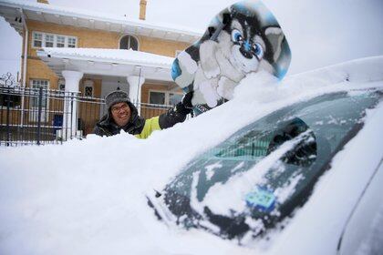 Francisco Sánchez sacando nieve de su auto en El Paso, Texas (Reuters)