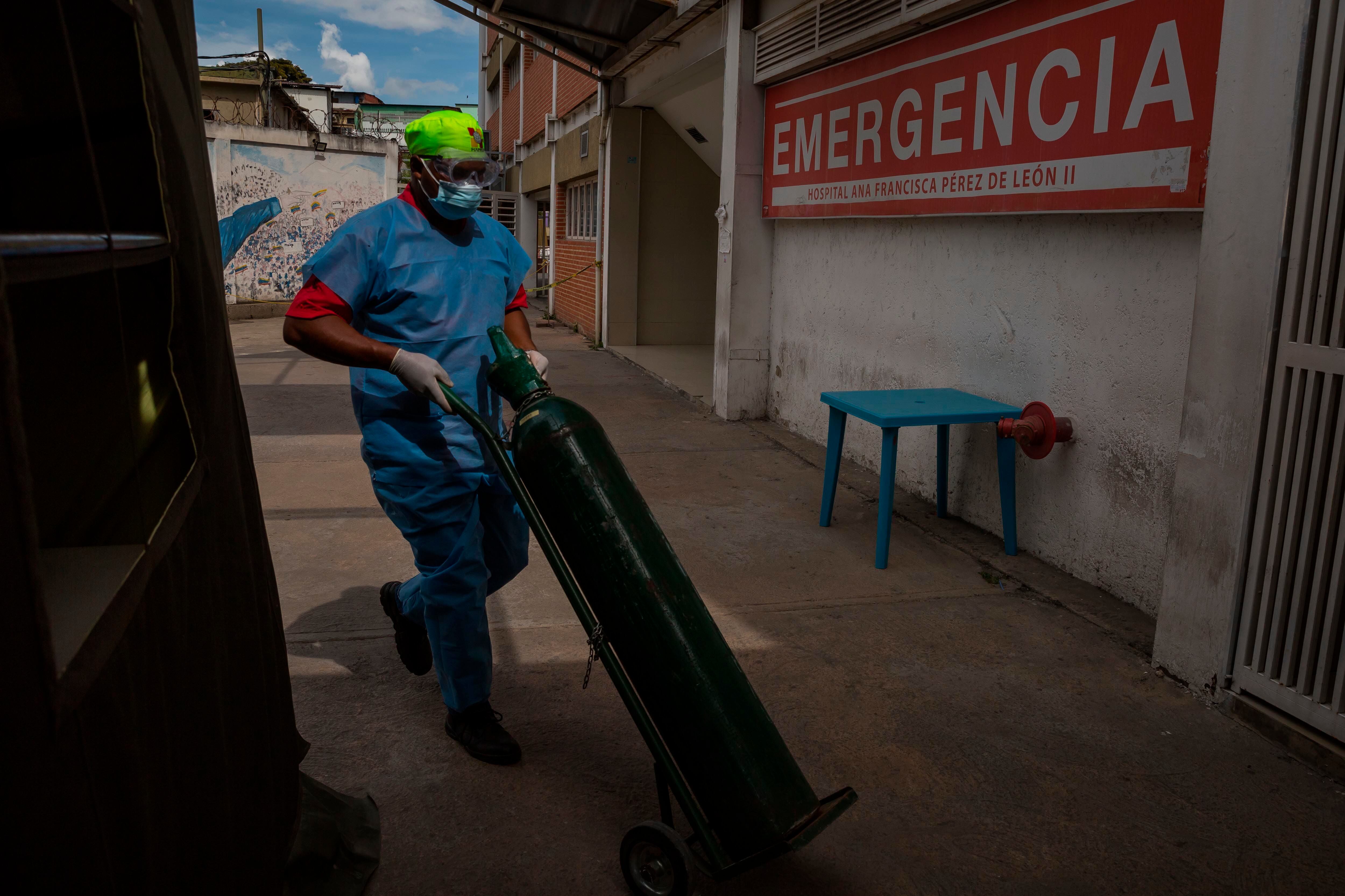 Un trabajador carga una bombona de oxígeno, el 26 de marzo del 2021, en el área de emergencias de un hospital público, en Caracas (EFE/ Miguel Gutiérrez/Archivo)