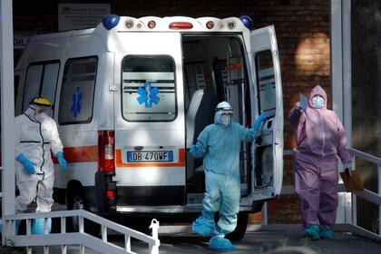 Medical workers wearing personal protective equipment (PPE) are seen next to an ambulance outside the Cotugno hospital as the battle with the coronavirus disease (COVID-19) intensifies, in Naples, Italy, November 9, 2020. REUTERS/Ciro De Luca