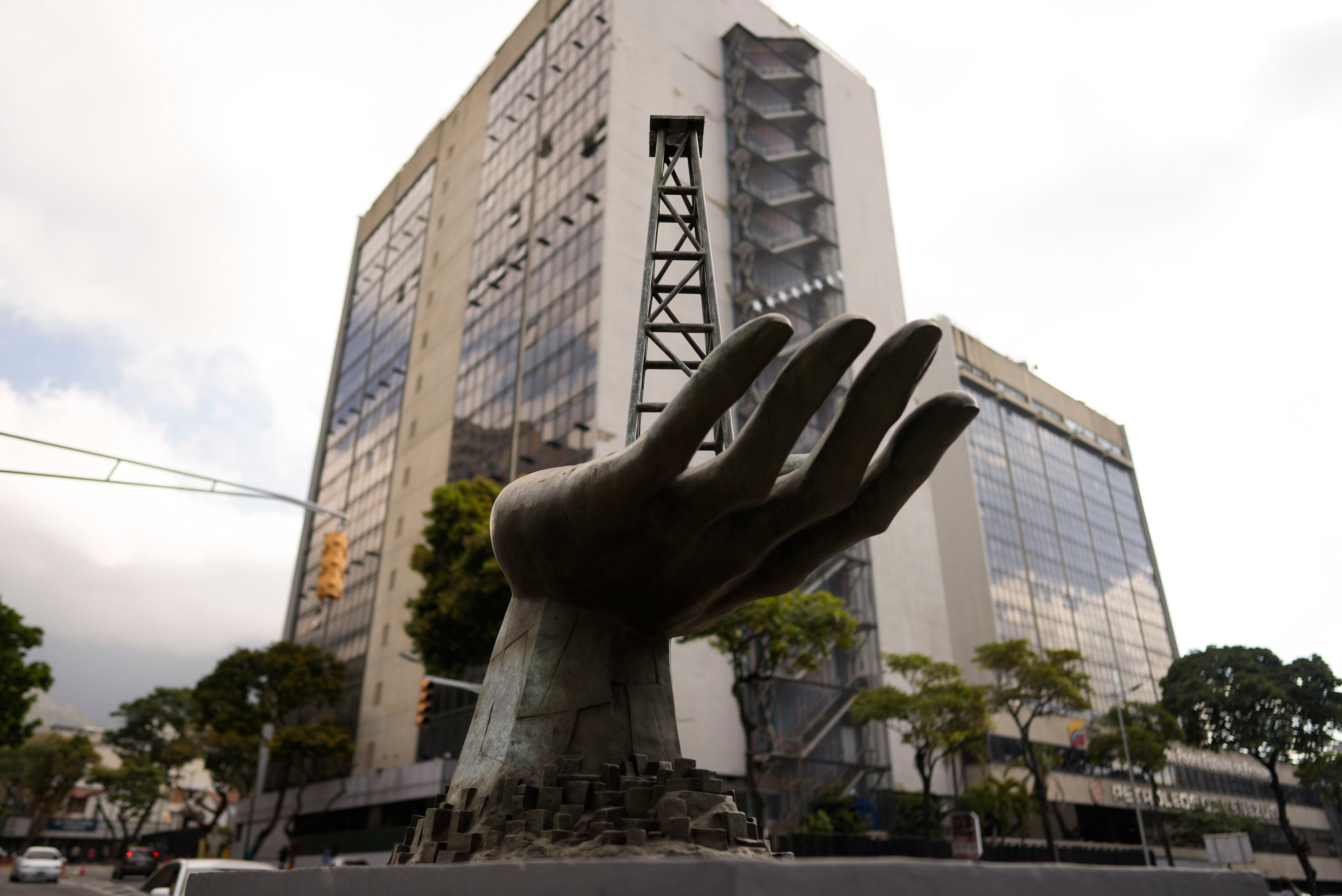 Una escultura de una mano sosteniendo un pozo de petróleo se ubica junto a la compañía Pdvsa en Caracas (Reuters)