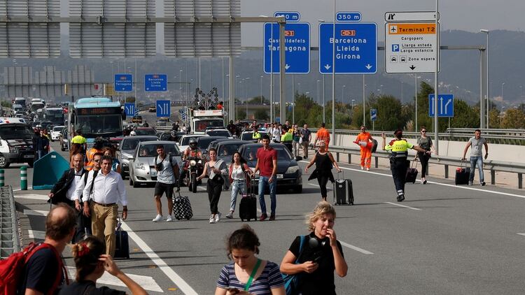 Muchos pasajeros tuvieron que caminar con sus maletas por la autovia para intentar llegar al aeropuerto (Reuters)