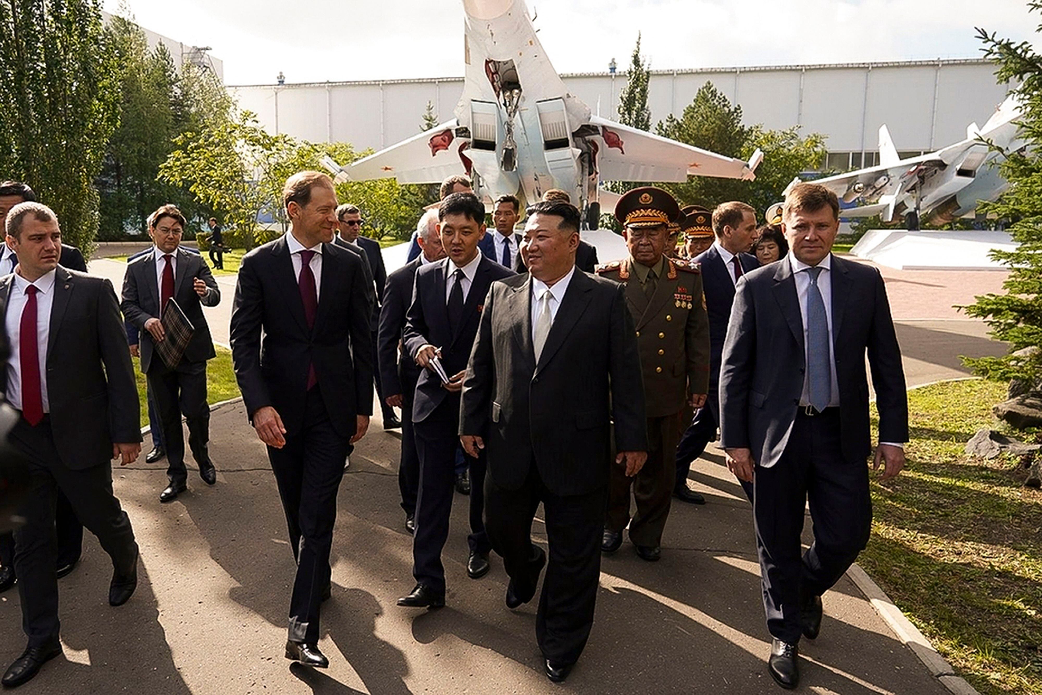 El gobernador de la región rusa de Khabarovsky Krai, Mikhail Degtyarev, el líder de Corea del Norte, Kim Jong Un (centro), escucha al viceprimer ministro y ministro de Comercio e Industria, Denis Manturov (centro, izquierda), durante una visita a una planta de fabricación de cazas, en Komsomolsk-on-Amur, a unos 6.200 km. (Canal de Telegram del gobernador de la región rusa de Khabarovsky Krai, Mikhail Degtyarev vía AP)