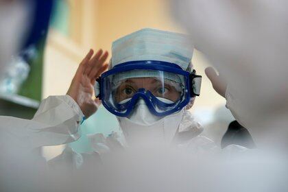 A medic puts on a protective suit ahead of a shift to treat patients suffering from the coronavirus disease (COVID-19) in a hospital in Tver, Russia October 13, 2020.  REUTERS/Tatyana Makeyeva