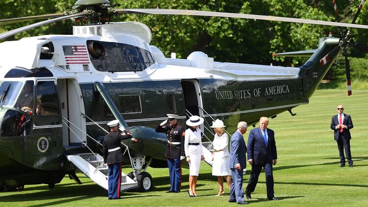 Trump y Melania descienden del helicóptero en los jardines del Palacio de Buckingham, donde los esperaban el príncipe Carlos y su esposa Camila (AFP)