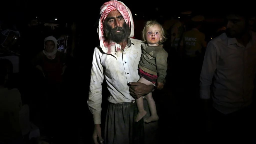 Un hombre yazidí con una menor, obligados a cruzar la frontera con Irak (AP)