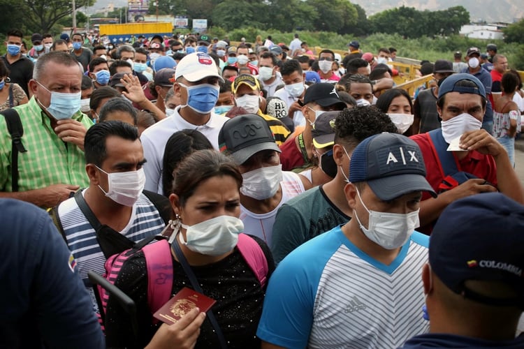 Venezolanos cruzando la frontera hacia Colombia, usando mascarilla para prevenir el coronavirus 
