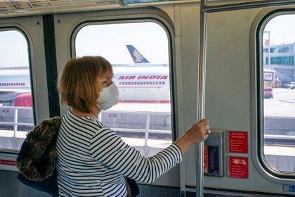 John F. of New York  At Kennedy International Airport, a woman wears a face mask while riding a Skytrain at her terminal. 