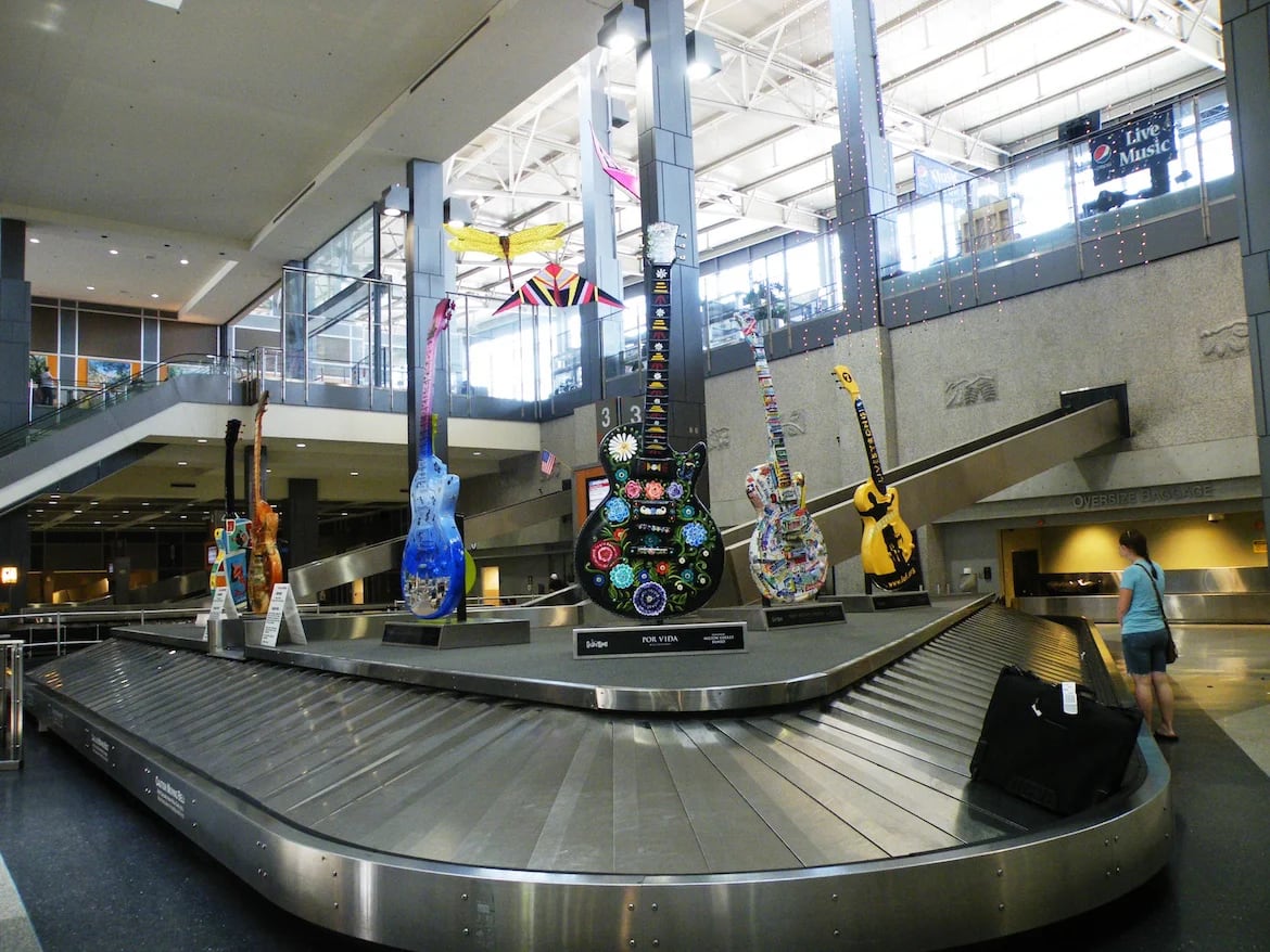 Una de las cintas de equipaje del aeropuerto de Austin (Texas) decorada con una exhibición de guitarras eléctricas
