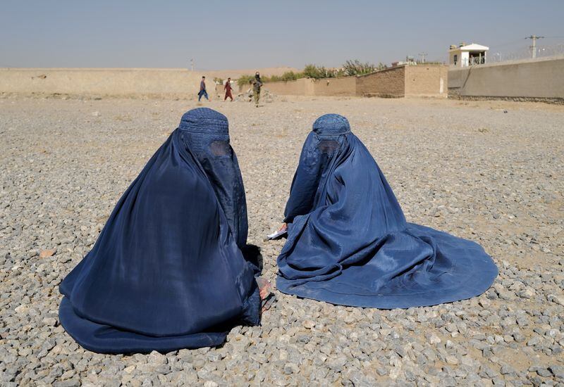 Mujeres afganas desplazadas esperan para recibir la ayuda de la agencia ACNUR frente al centro de distribución en las afueras de Kabul