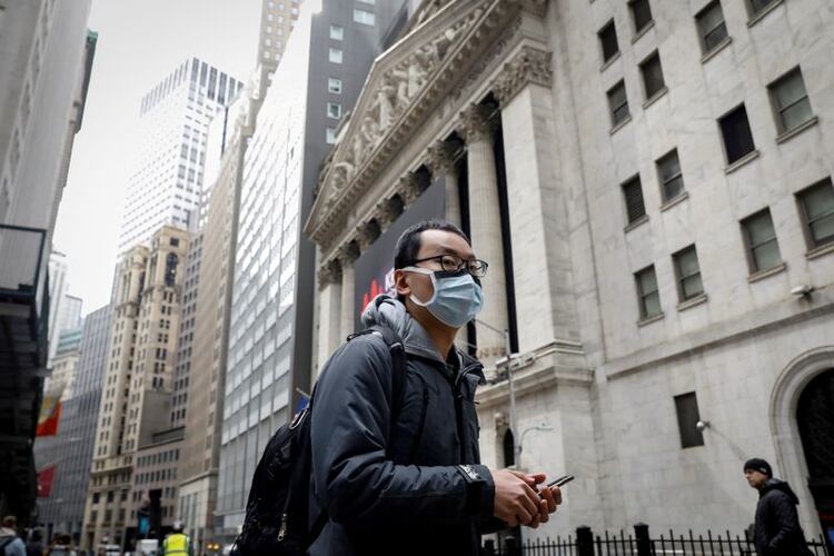 Un hombre usa una mascarilla en Wall St., cerca de la Bolsa de Nueva York 