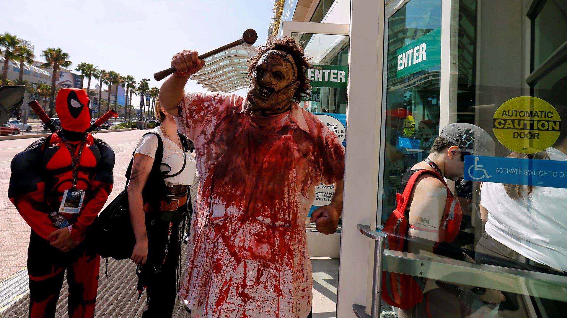 Fanáticos disfrazados como Deadpool y zombie esperan par que sus armas sean revisadas por la policía (Reuters)