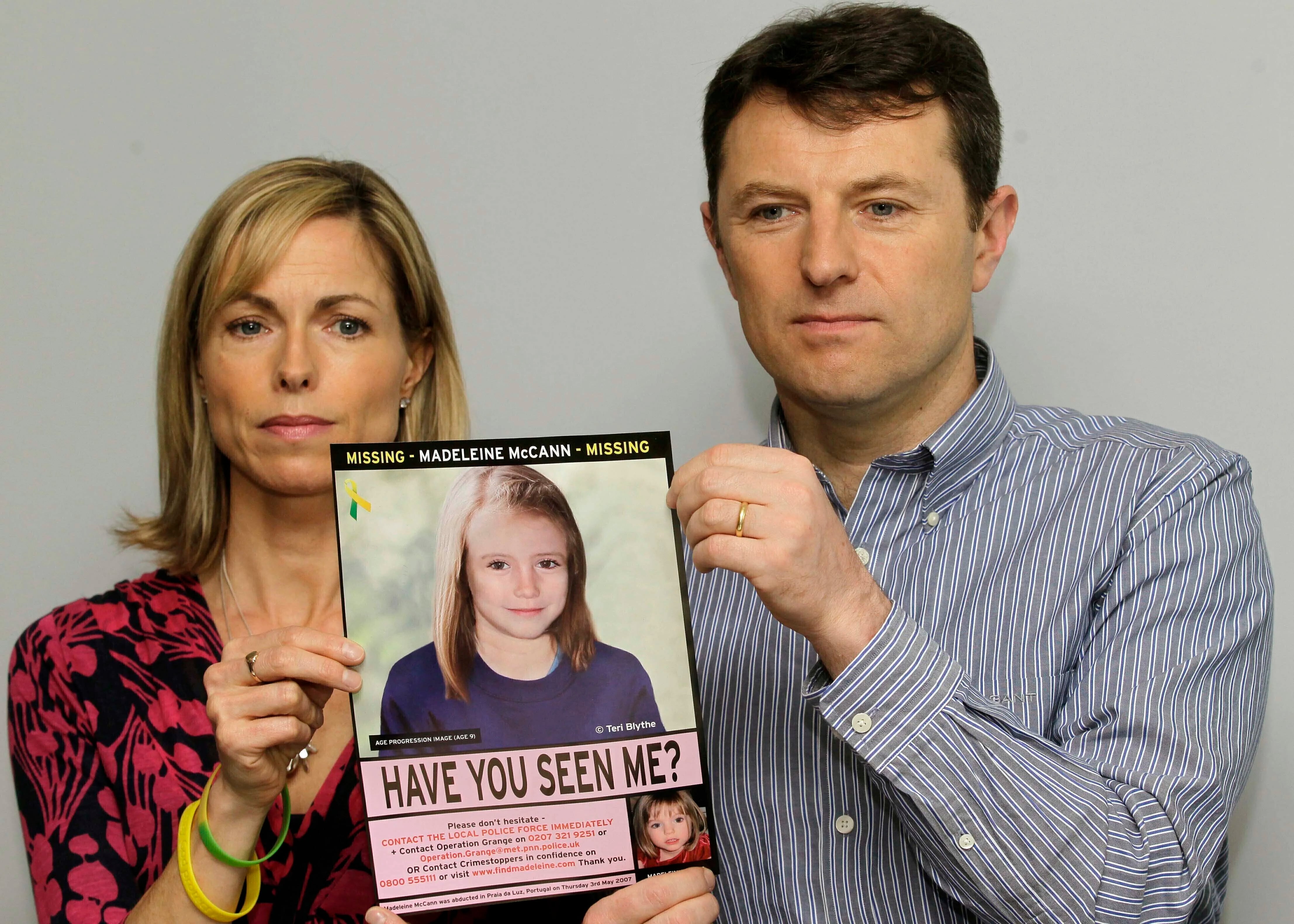 Kate y Gerry McCann posan para los medios con un cartel de búsqueda que ofrece una imagen generada por computadora sobre la posible progresión de la edad de su hija Madeleine, que desapareció en Portugal en 2007, durante una conferencia de prensa en Londres, el 2 de mayo de 2012. (AP Foto/Sang Tan, archivo)