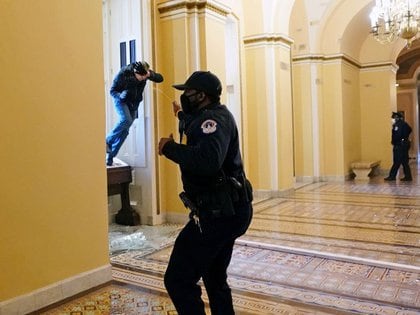 Un oficial de policía del Capitolio de EEUU dispara gas pimienta a un manifestante que ingresó al edificio del Capitolio (Kevin Dietsch/Pool vía REUTERS)