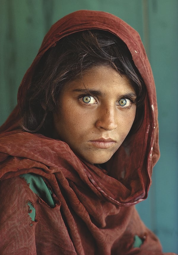 La niña afgana, Sharbat Gula, en el campo de refugiados Nasir Bagh en Pakistán. La identidad de la protagonista de la foto no se conocía inicialmente, y en 2002 el equipo de National Geographic la identificó mientras se encontraba en una remota región de Afganistán, tras regresar a su país natal desde el campo de refugiados en 1992, confirmando su identidad mediante el reconocimiento del iris. Steve McCurry, 1984. 