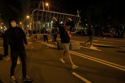 Un hombre avanza con una valla en Barcelona durante la manifestación por la libertad de Hásel este viernes por la noche (REUTERS/Albert Gea)